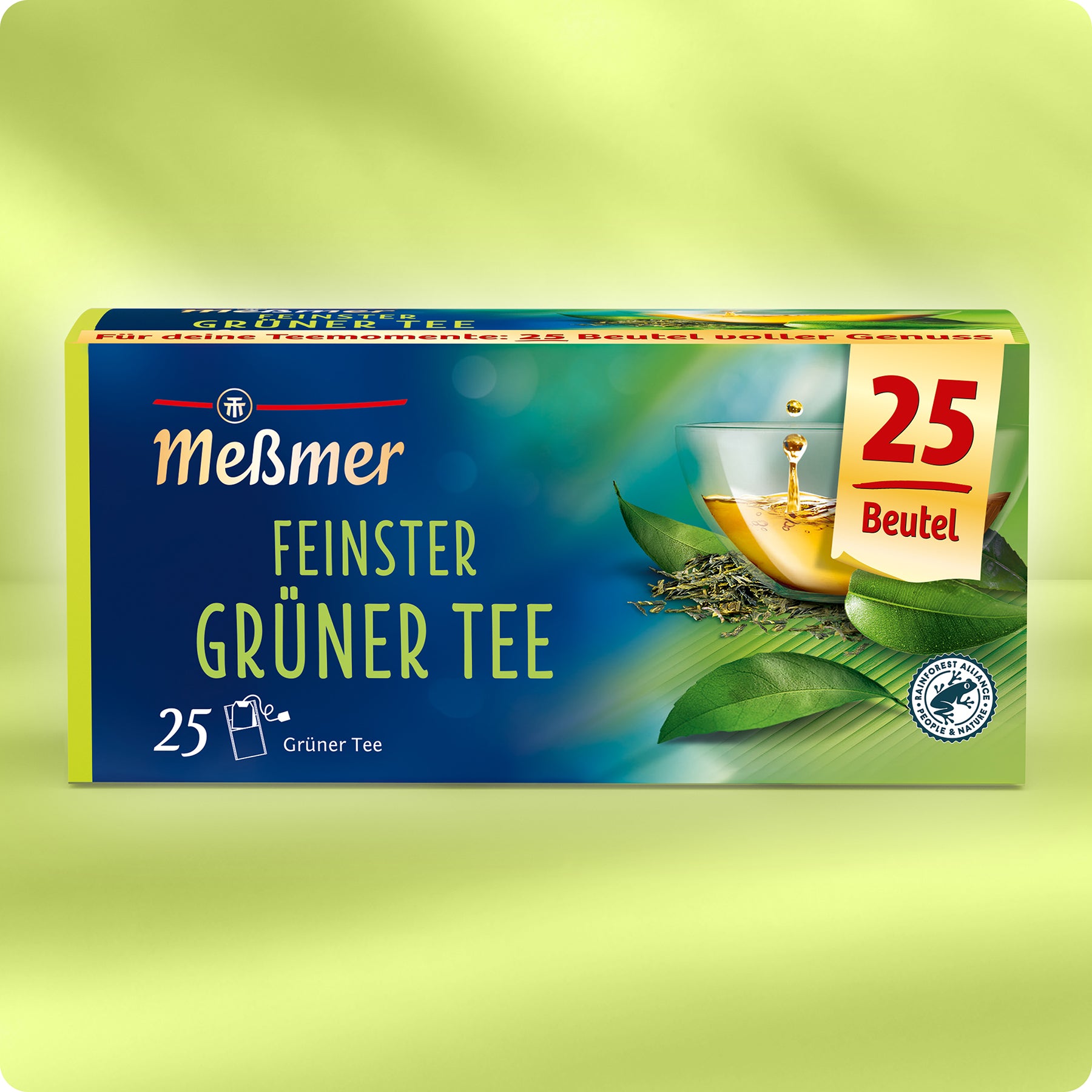 Eine Schachtel Meßmer DE Grüner Tee mit 25 Teebeuteln, abgebildet mit einer Glastasse mit grünem Tee, frischen Blättern und einer entspannenden grün-blauen Kulisse.