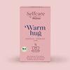 Verpackung von Bio Warm Hug Kräuter-Früchtetee mit Bio-Siegel, Hinweis auf Hibiskus, Erdbeere, Zimt und Vanille-Aroma, präsentiert auf zartrosa Hintergrund in entspannter Atmosphäre.
